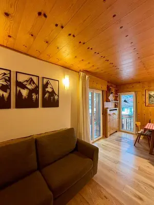 a living room with a couch and a table at Pragma Apartments - Appartamento Arcade in Predazzo