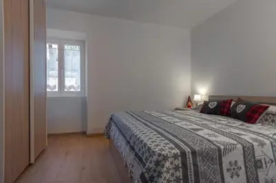 a bedroom with a bed and a window at DolomiApartments - Appartamento Avisio in Predazzo