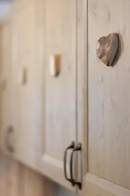 a wooden cabinet with a knob on the wall at DolomiApartments - Appartamento Avisio in Predazzo