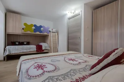 a bedroom with two beds in a room at DolomiApartments - Appartamento Avisio in Predazzo