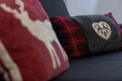 a red pillow next to a red pillow with a heart at DolomiApartments - Appartamento Avisio in Predazzo