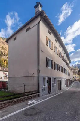 a large white building on the side of a street at DolomiApartments - Appartamento Avisio in Predazzo