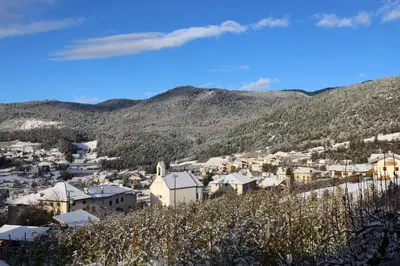 a small town on a hill with mountains in the background at Casetta Turati in Castelfondo