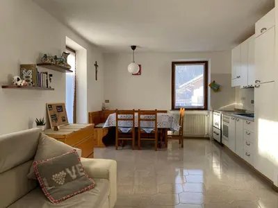 a kitchen and living room with a couch and a table at Casetta Turati in Castelfondo