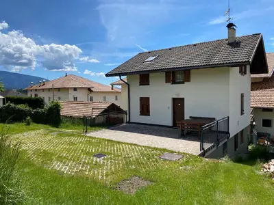 a white house with a porch and a bench at Casetta Turati in Castelfondo