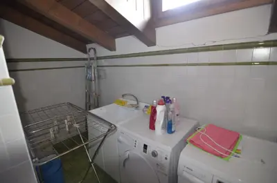a laundry room with a washing machine and a sink at Holidays on Dolomites in Villanova