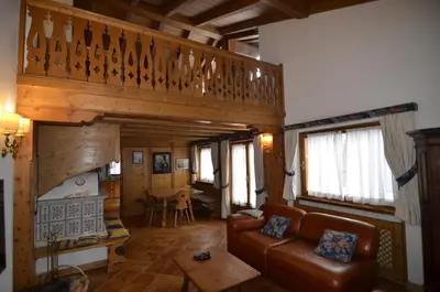 a living room with a couch and a staircase at Holidays on Dolomites in Villanova