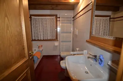 a bathroom with a sink and a toilet and a mirror at Holidays on Dolomites in Villanova