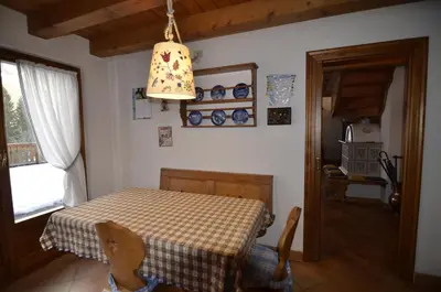 a dining room with a table and a lamp at Holidays on Dolomites in Villanova