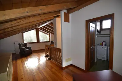 a large living room with wooden floors and a staircase at Holidays on Dolomites in Villanova