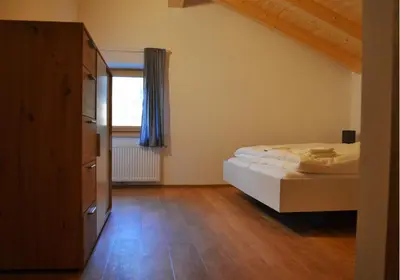 a small bedroom with a bed and a window at Gasthof Faust in Vols am Schlern