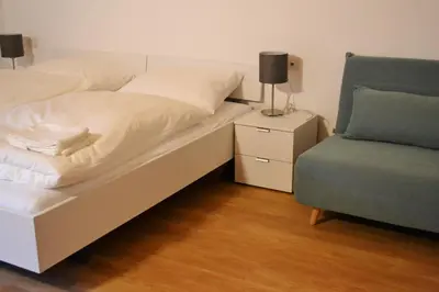 a bed and a chair in a room at Gasthof Faust in Vols am Schlern