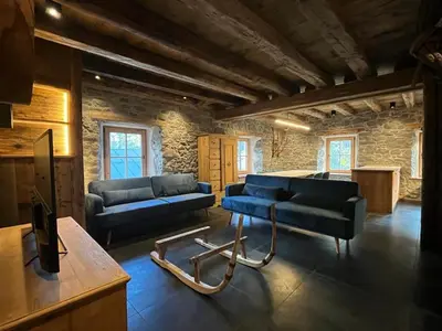 a living room with two blue couches and a table at Brand new duplex in the Dolomites - Lupo Bianco in Rocca Pietore