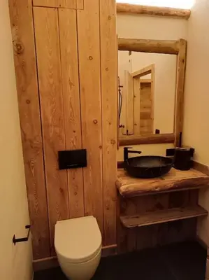 a bathroom with a white toilet and a mirror at Brand new duplex in the Dolomites - Lupo Bianco in Rocca Pietore