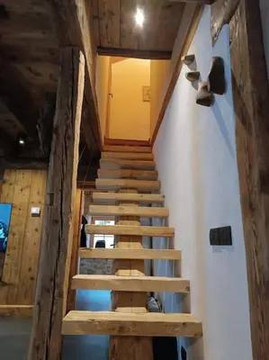 a staircase in a room with wooden ceilings at Brand new duplex in the Dolomites - Lupo Bianco in Rocca Pietore