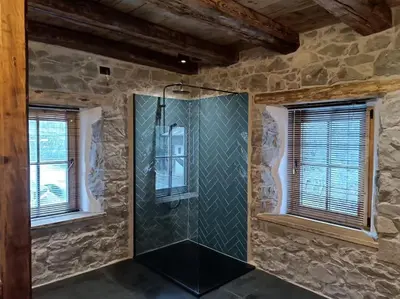 a glass shower in a room with two windows at Brand new duplex in the Dolomites - Lupo Bianco in Rocca Pietore