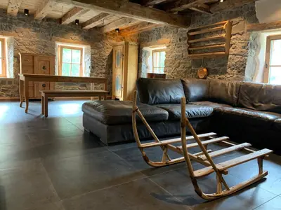 a living room with a leather couch and a chair at Brand new duplex in the Dolomites - Lupo Bianco in Rocca Pietore