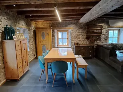 a dining room with a wooden table and blue chairs at Brand new duplex in the Dolomites - Lupo Bianco in Rocca Pietore