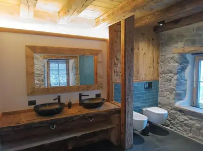 a bathroom with two sinks and a toilet at Brand new duplex in the Dolomites - Lupo Bianco in Rocca Pietore