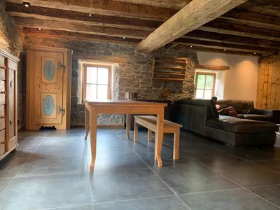 a living room with a table and a couch at Brand new duplex in the Dolomites - Lupo Bianco in Rocca Pietore