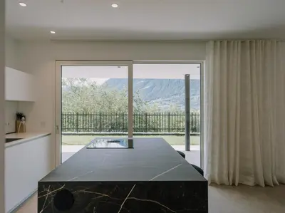 a kitchen with a large glass door to a balcony at The Hills Merano in Merano