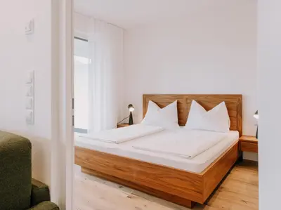 a bed with white sheets and pillows in a bedroom at The Hills Merano in Merano