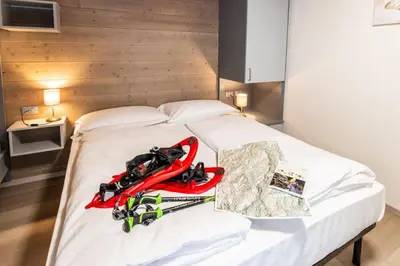 a bed with a pair of skis on it at B&B Piazza in Fondo