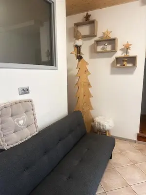 a living room with a couch and a christmas tree on the wall at B&B Piazza in Fondo