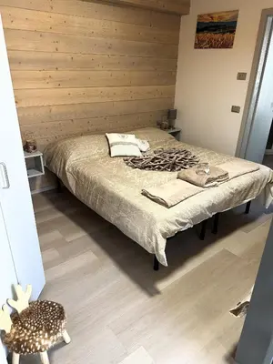 a bedroom with a bed and a wooden wall at B&B Piazza in Fondo