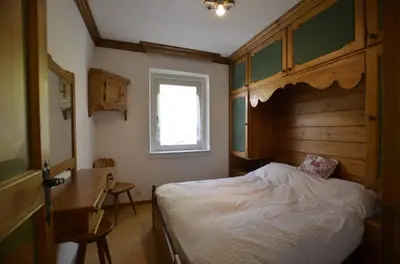 a bedroom with a bed with a wooden headboard and a window at One bedroom apartment on the promenade in Maion