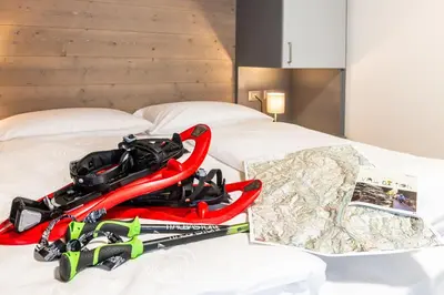 a pile of ski equipment sitting on top of a bed at Appartamento vacanze Piazza in Fondo