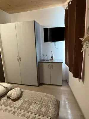 a bedroom with a bed and a table and cabinets at Appartamento vacanze Piazza in Fondo