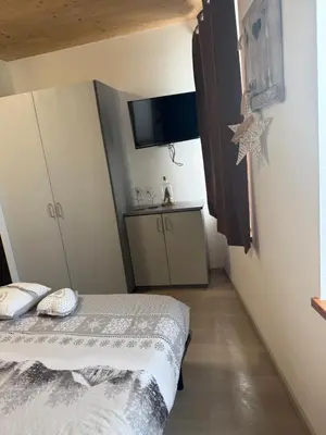a small bedroom with a bed and a tv at Appartamento vacanze Piazza in Fondo