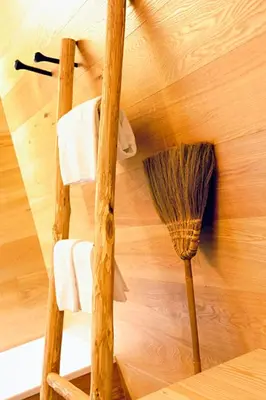 a broom and towels on a wooden wall at Dichterstube im Living Kampill in Bolzano