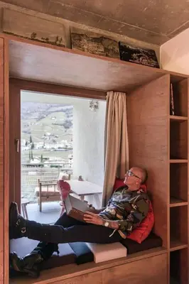 a man sitting in a bunk bed with a laptop at Dichterstube im Living Kampill in Bolzano