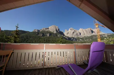 a purple chair sitting on a porch with a view of mountains at Apartments Nevada in Colfosco