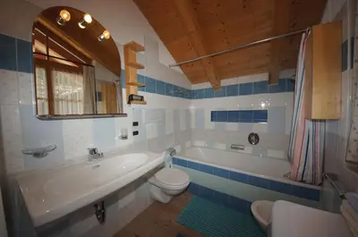 a bathroom with a tub and a toilet and a sink at Apartments Nevada in Colfosco