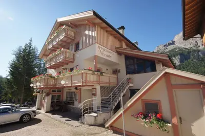 a building with balconies and a car parked in front of it at Apartments Nevada in Colfosco