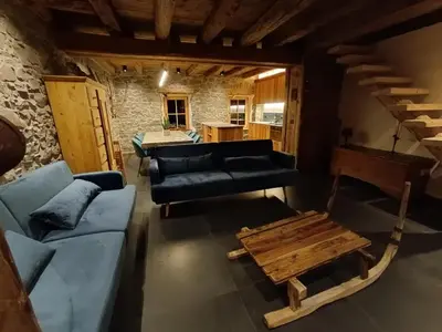 a living room with a couch and a table at Brand new Duplex in the Dolomites - Picchio Rosso in Rocca Pietore