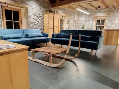 a living room with blue couches and a wooden table at Brand new Duplex in the Dolomites - Picchio Rosso in Rocca Pietore