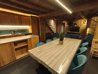 a kitchen with a wooden table and blue chairs at Brand new Duplex in the Dolomites - Picchio Rosso in Rocca Pietore