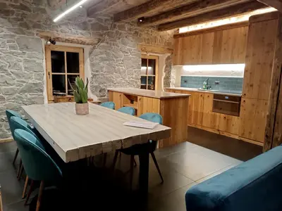 a kitchen with a wooden table and blue chairs at Brand new Duplex in the Dolomites - Picchio Rosso in Rocca Pietore