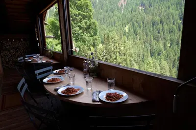 a table with plates of food on it in front of a window at Beautiful barn with garden and stunning view in Colle Santa Lucia