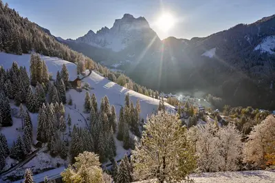 a snow covered mountain with the sun in the background at Beautiful barn with garden and stunning view in Colle Santa Lucia