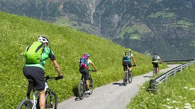a group of people riding bikes down a mountain road at Dolomitissime Holiday Homes Marmolada in Rocca Pietore