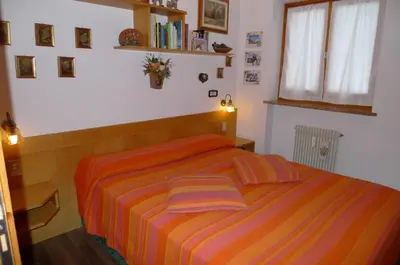 a bedroom with a bed with two pillows on it at Dolomitissime Holiday Homes Marmolada in Rocca Pietore