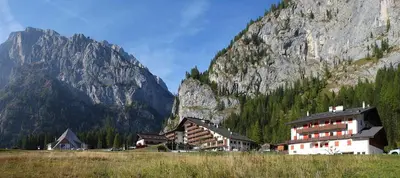 a large building in front of a mountain at Dolomitissime Holiday Homes Marmolada in Rocca Pietore