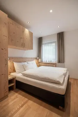 a bedroom with a large bed in a room at Haus Gabi Runggaldier in San Pietro in Gardena