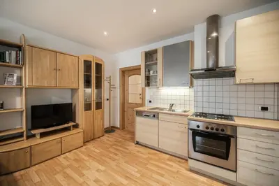 a kitchen with wooden cabinets and a stove top oven at Haus Gabi Runggaldier in San Pietro in Gardena