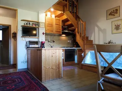 a kitchen with a stairway and a kitchen with a counter at Appartamento Pepe by Sunhome Fiemme in Castello di Fiemme
